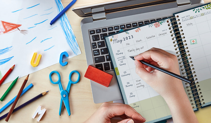 A person writes in the columned layout of the Family Life Book.