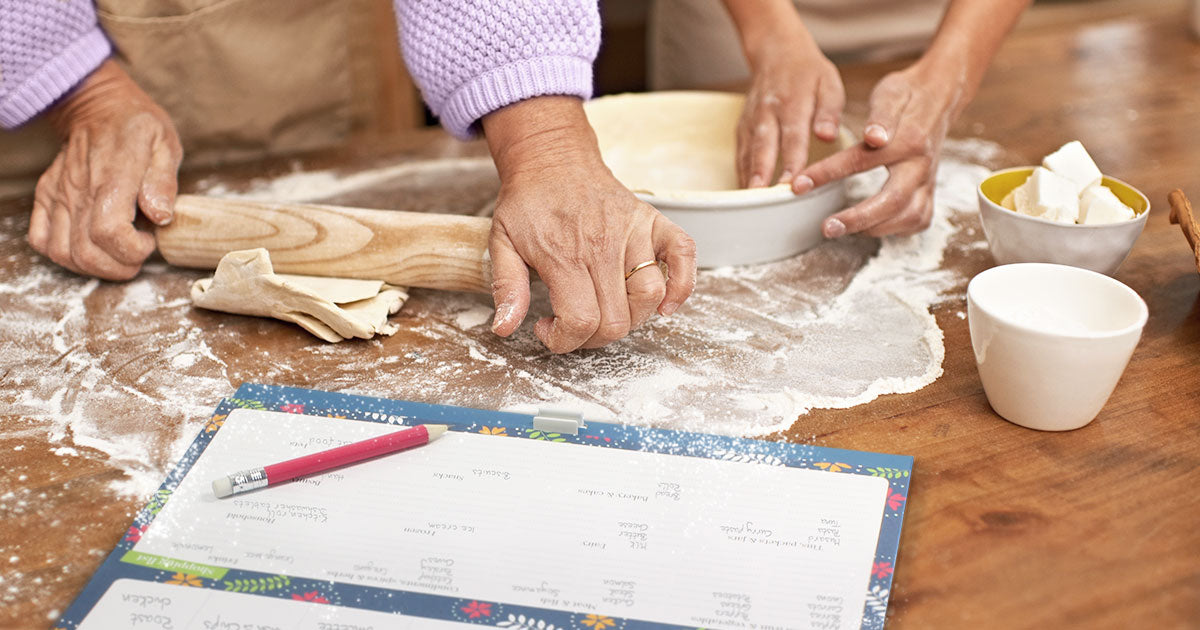 Two people making a pie with the Boxclever Press Big Shop and Menu Planner Fridge List