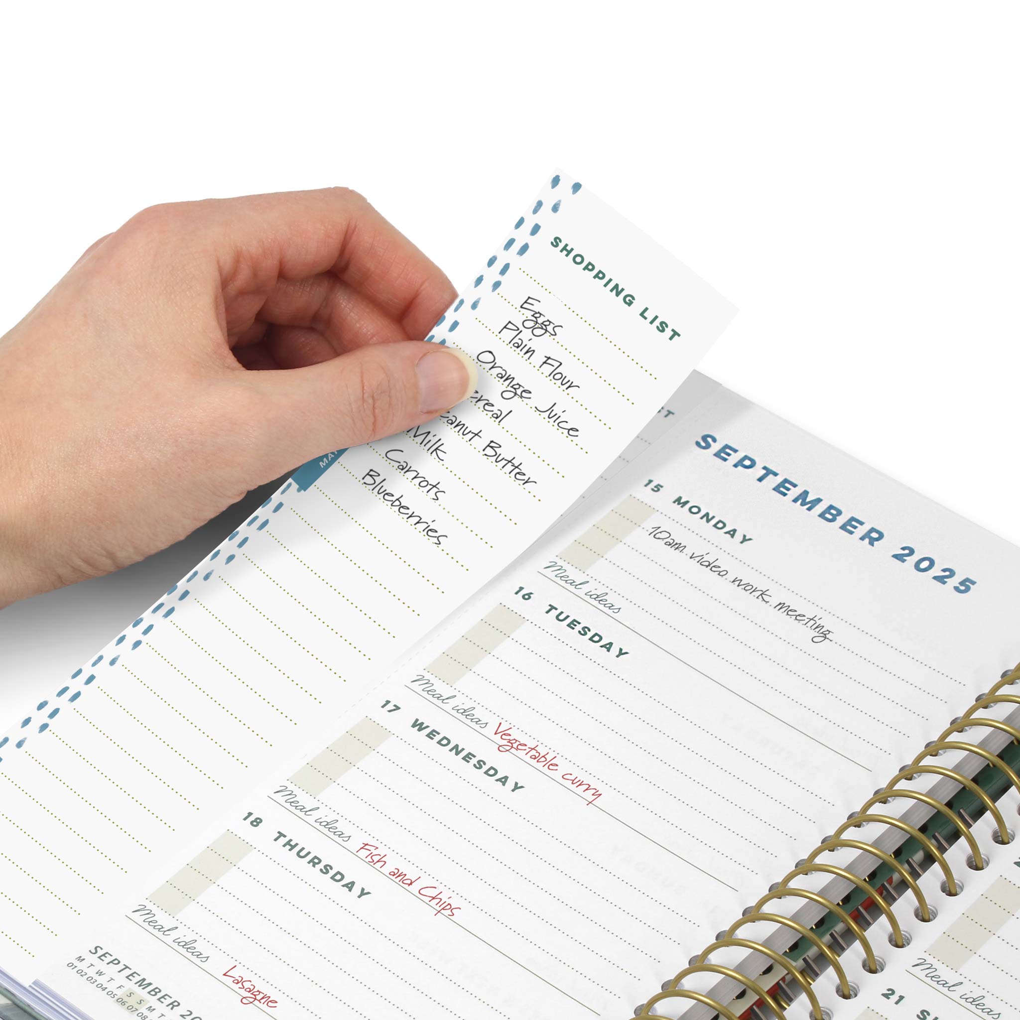 A hand removing a perforated shopping list from the diary