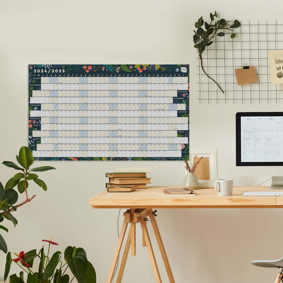 Academic wall planner with leaf design hung above a wooden table