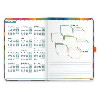 An open diary planner with a goals and dreams for the year page and a page with year micro calendars for 2025 and 2026.