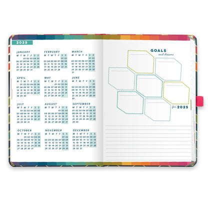 An open diary planner with a goals and dreams for the year page and a page with year microcalendars for 2025.