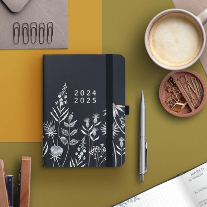 A bag-sized academic weekly planner with a dark blue and silver floral design