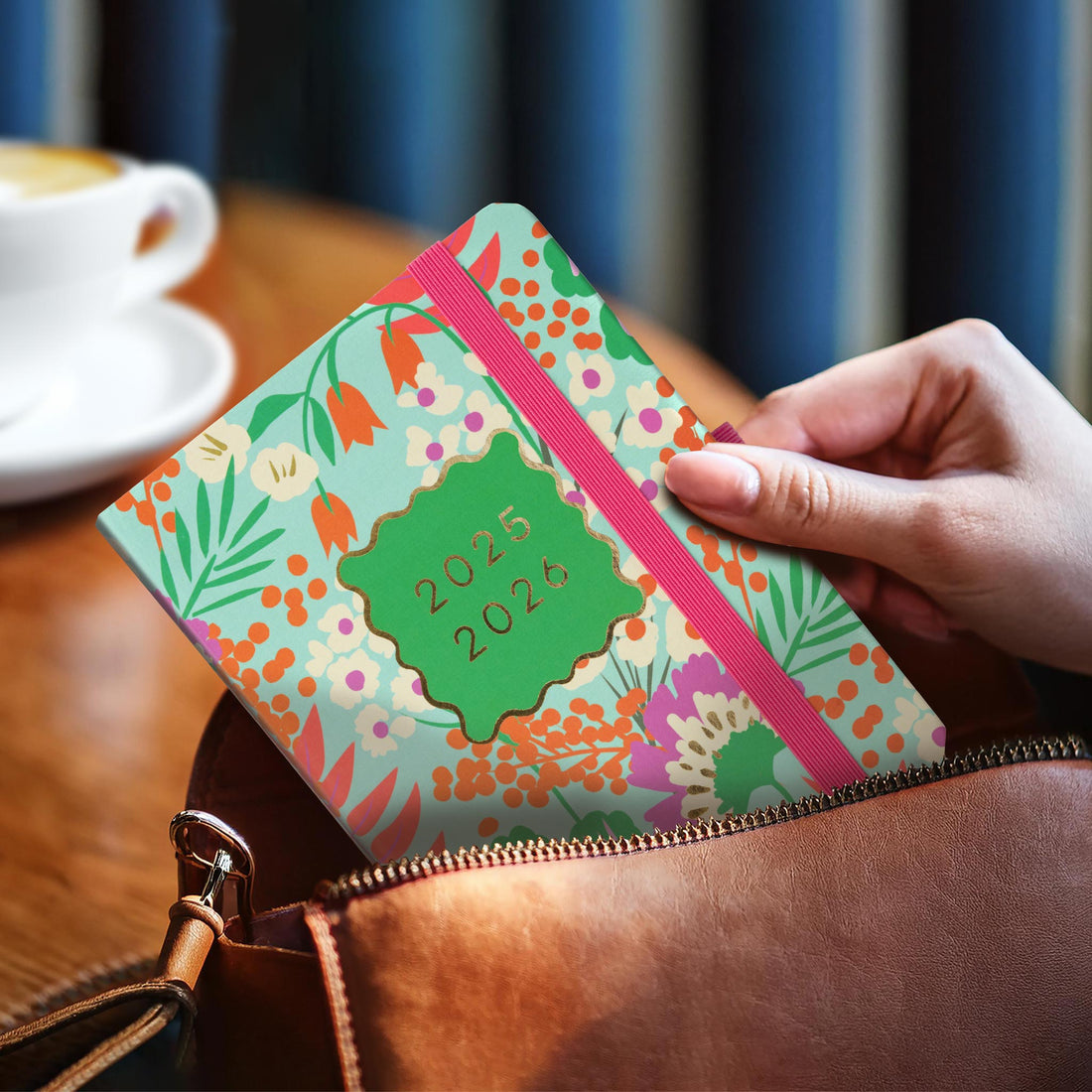 The Everyday academic planner being put into a leather bag. 