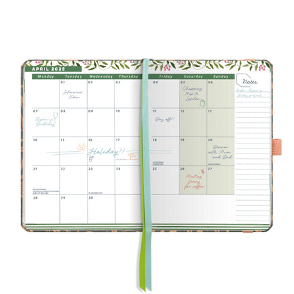 An open page diary spread with a month at a glance calendar, note space and ribbon page markers.
