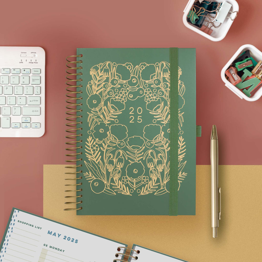 A spiral bound diary planner with green floral design 