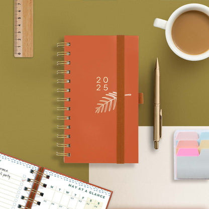 A spiral bound, pocket sized weekly planner with orange cover