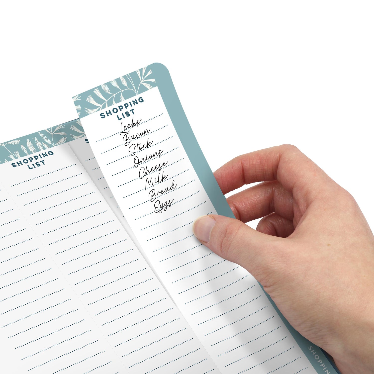 A hand removing a perforated shopping list from the diary.