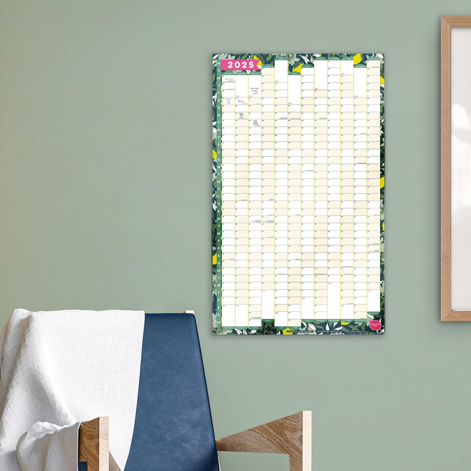 Portrait wall planner hung on a green wall. 